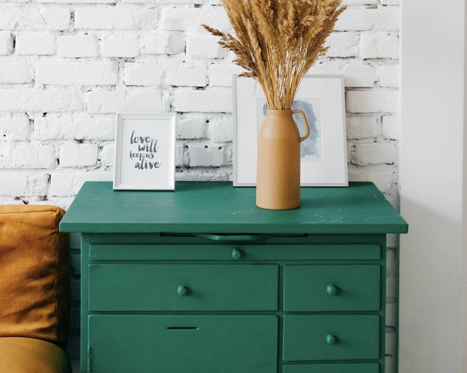 A stylish green drawer with decorative items on top
